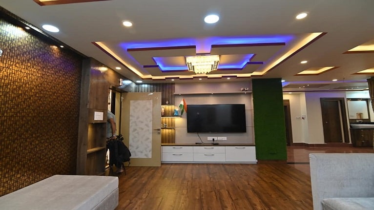 Living room with layered false ceiling and TV unit